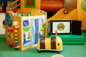 Motorikspielzeug und Bienen-Rutschfahrzeug im Spielzimmer