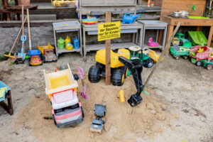 Sandspielplatz mit Baggern und Kinderfahrzeugen